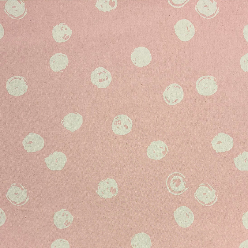 Blush spotted upholstery fabric draped to show texture