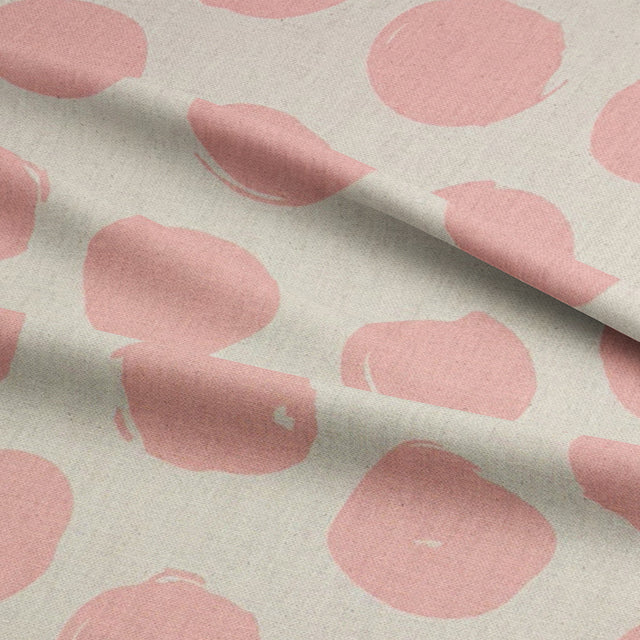 Spotted polka dot curtain fabric in blush pink, adding a contemporary look to any space.