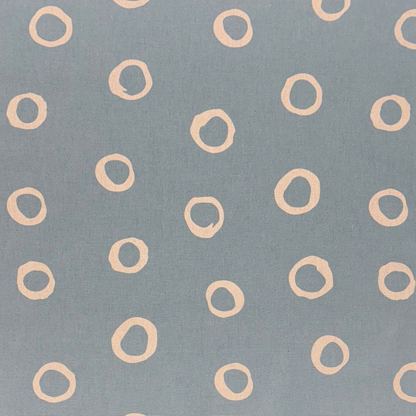 Denim blue spotted polka dot upholstery fabric with a contemporary hand-painted dot pattern, perfect for modern interiors.