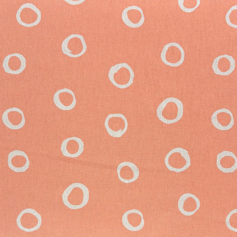 Peach spotted polka dot upholstery fabric with a warm, inviting feel, ideal for classic and modern interiors.