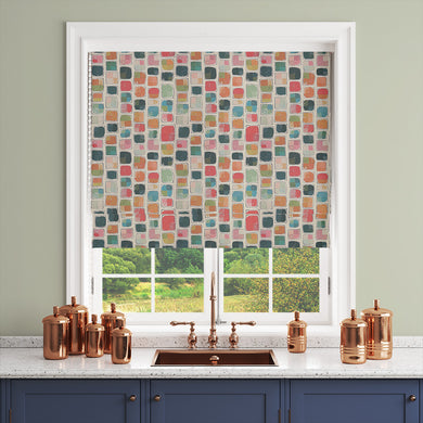 Modern multicoloured curtain fabric blind with a lively patchwork pattern.